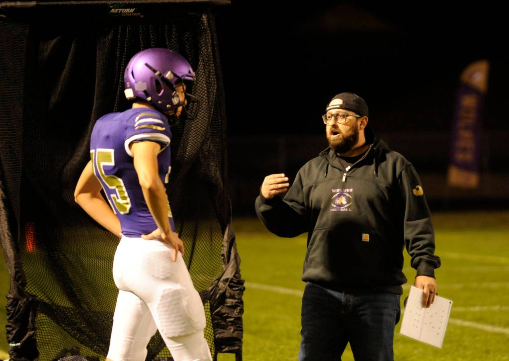 Sequim Gazette photo by Michael Dashiell / Cody Buckmaster, Sequim High football special teams coach (right), talks with Jack Henninger during an Oct. 13 league match-up with North Mason.