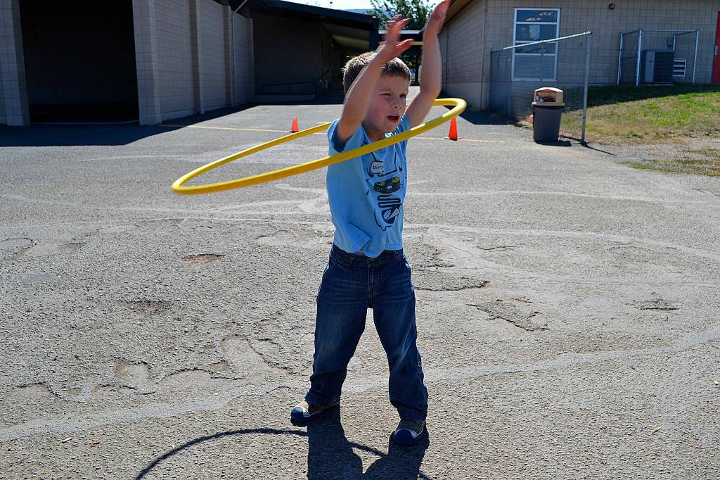 Sequim Gazette file photo by Matthew Nash/ Five-year-old Win Jones puts his best efforts into hula-hooping during his first recess as a kindergartener in 2011.