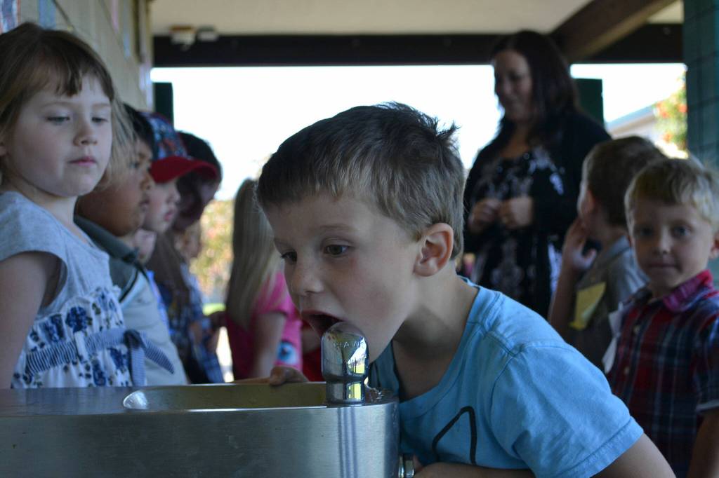 Sequim Gazette file photo by Matthew Nash/ Kindergarteners line up after recess at Helen Haller Elementary on their first day of kindergarten in 2011 as fellow kinder Win Jones takes a sip of water.