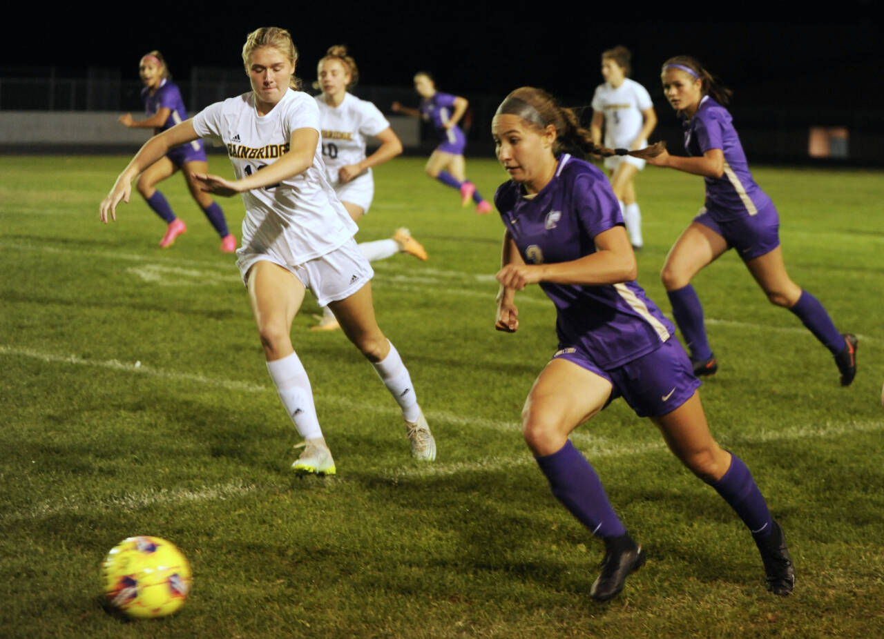 Sequim Gazette photos by Michael Dashiell
With teammate Sasha Yada, left, racing into Spartan territory, Sequims Taryn Johnson looks to advance the ball against Bainbridge in a Sept. 26 Olympic League match-up.