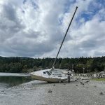 Sequim Gazette photo by Matthew Nash/ A sailboat called Dire Straits beached sometime between Sept. 24-25 and thanks to the help from a John Wayne Marina tenant it was returned to the middle of Sequim Bay the afternoon of Sept. 29.