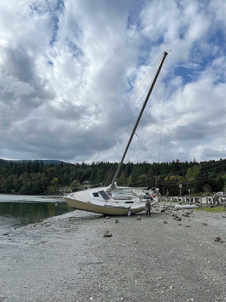 Sequim Gazette photo by Matthew Nash/ A sailboat called Dire Straits beached sometime between Sept. 24-25 and thanks to the help from a John Wayne Marina tenant it was returned to the middle of Sequim Bay the afternoon of Sept. 29.
