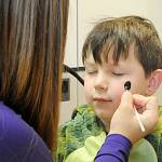 Sequim Gazette file photo by Matthew Nash/ 
Bowie Dockery gets a spider painted on his face by Azalea Loveday at the Sequim High School Haunted Hallways event in 2022. Loveday was one of many cheerleaders offering festive face painting.