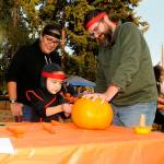 Sequim Gazette file photo by Matthew Nash/ 
Ninja Aiden Havel-Beristain carves a pumpkin with his ninja parents Gabriela Beristain-Havel and Tim Havel at the Sequim Prairie Granges Trunk-or-Treat in 2022. The event returns on Oct. 28.