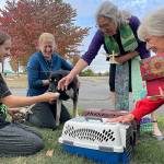 Sequim Gazette photo by Matthew Nash/ Daughter-and-mother Avonlea and Julie Lawrence, on left, accept St. Francis medallions from Pastor Desi Larson, and JoAnn Sahs-Cavin after their cats, dog and chicken were blessed at Trinity United Methodist Churchs Blessing of the Animals ceremony.