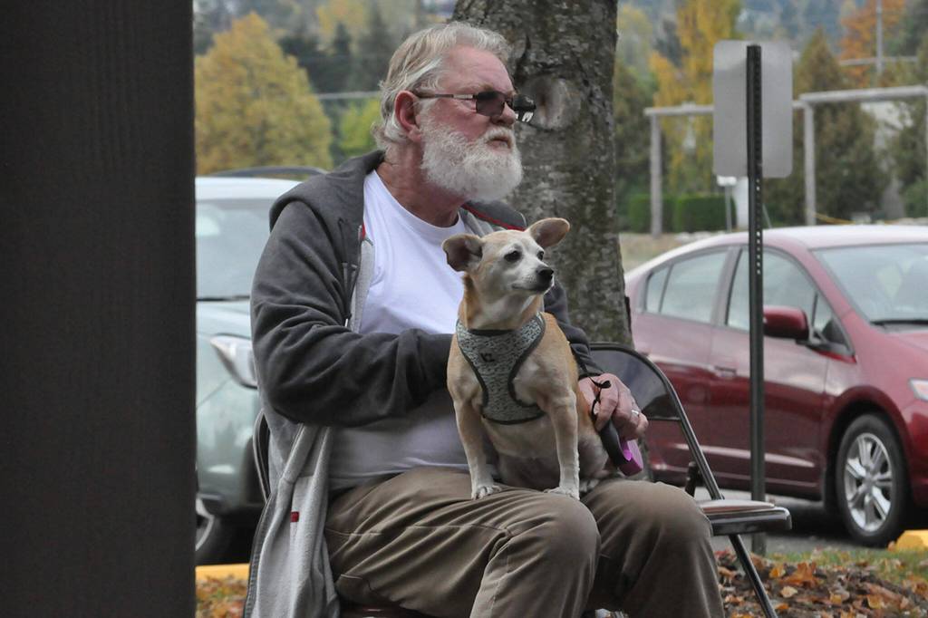 Sequim Gazette photo by Matthew Nash/ Bobby Davis holds Ruby the dog during a song at Trinity United Methodist Churchs Blessing of the Animals ceremony.