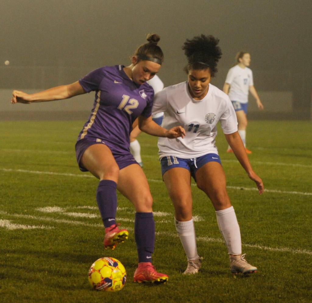 Sequim Gazette photo by Michael Dashiell / Sequims Olive Bridge, left and Olympics Missie Denis vie for the ball in the first half of an Oct. 12 league game in Sequim.
