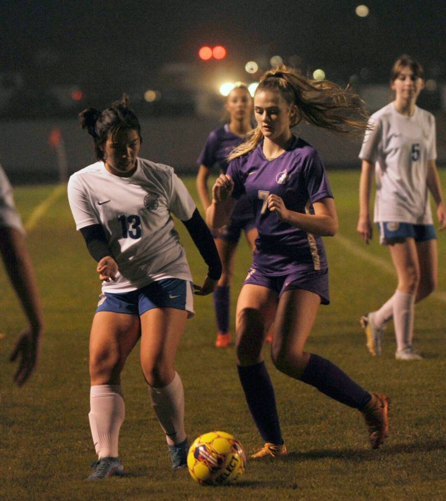 Sequim Gazette photo by Michael Dashiell / Sequims Eve Breithaupt, right, looks to pressure Olympics Emiko Carrier-Berndt deep in Trojan territory in the first half of a an Oct. 12 league match-up in Sequim.