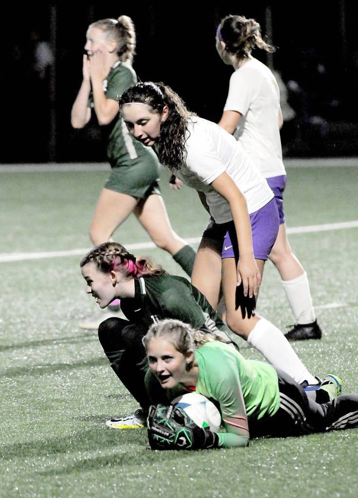 Photo by Keith Thorpe/Olympic Peninsula News Group
Sequim goalkeeper Kalli Grove clutches the ball after withstanding a shot by Port Angeles Pyper Alton, lower left, on Oct. 10 in Port Angeles.
