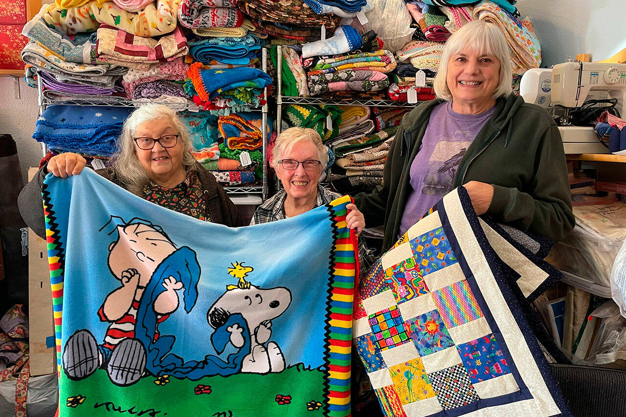 Sequim Gazette photo by Matthew Nash/ 
Project Linus volunteers, from left, Cheryl Smoker, LaRue Robirts and Connie Torrence are three of 200 quilters/volunteers who help provide quilts or help the nonprofit share blankets with children ages 0-18 facing a difficult situation. The store front is open 11 a.m.-3 p.m. Sundays, and 10 a.m.-3 p.m. Wednesdays and Thursdays at 33 Valley Center Place in Carlsborg.
