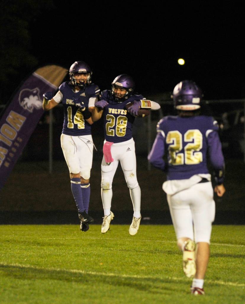Sequims Zeke Schmadeke (14), Adrian Aragon (28) and Patrick Elias celebrate a 36-0 thumping of North Mason at Sequim Highs Homecoming game on Oct. 13. See story, B-2.