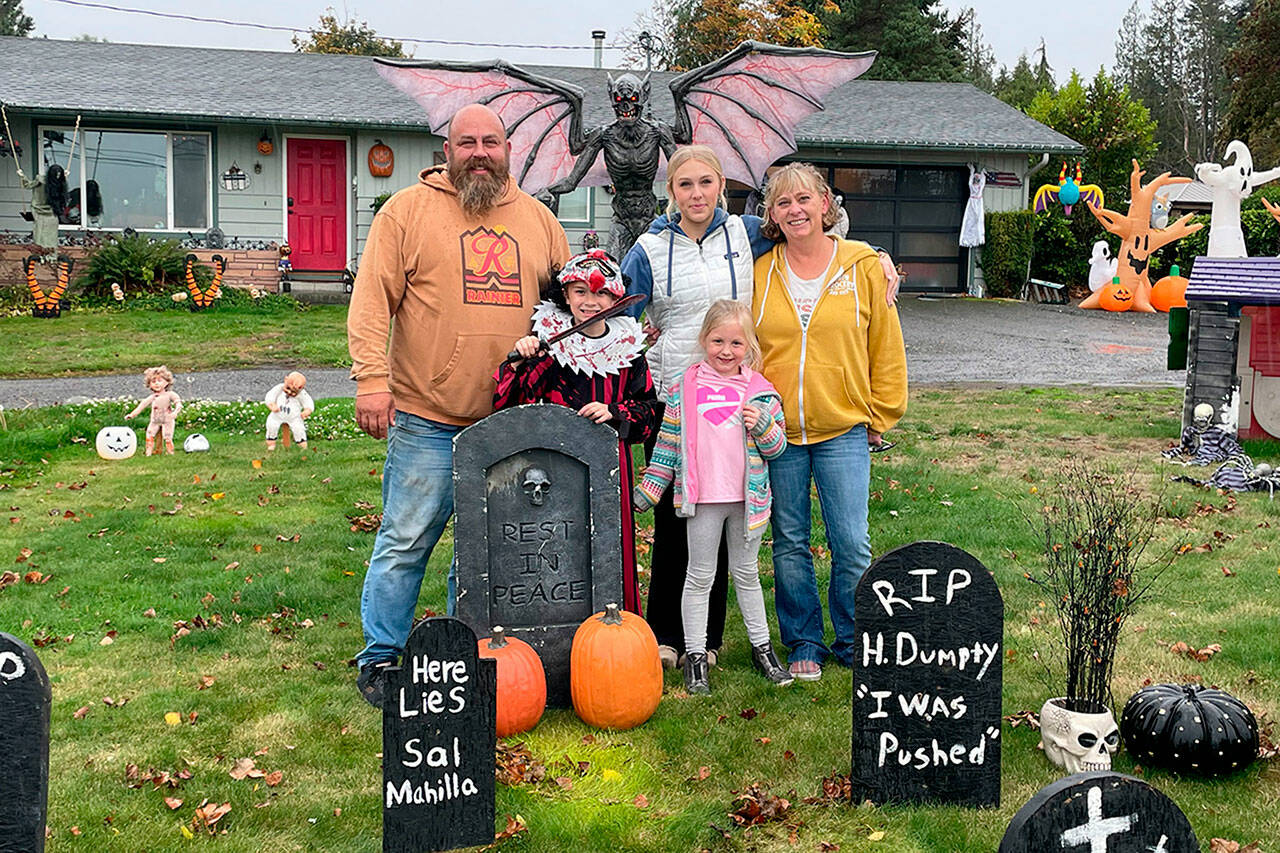 Sequim Gazette photo by Matthew Nash/ 
The Henning family, from left, Josh Henning, grandson Rylee Robinson, daughter Abby Henning, niece Clara Cergoli, and Ruby Henning stand in their family graveyard in front of their Old Olympic Highway home where theyve decorated for 14-plus years for Halloween and Christmas.