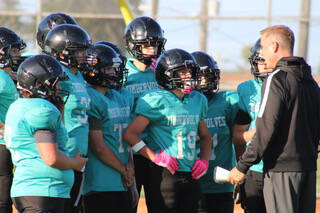 Photo courtesy of Sequim Middle School football / Coach Greg Glasser talks with Ezra Fitts (19) and other Timberwolves players as the Sequim Middle School football squad takes on a league foe. The SMS team went 6-0 this season.