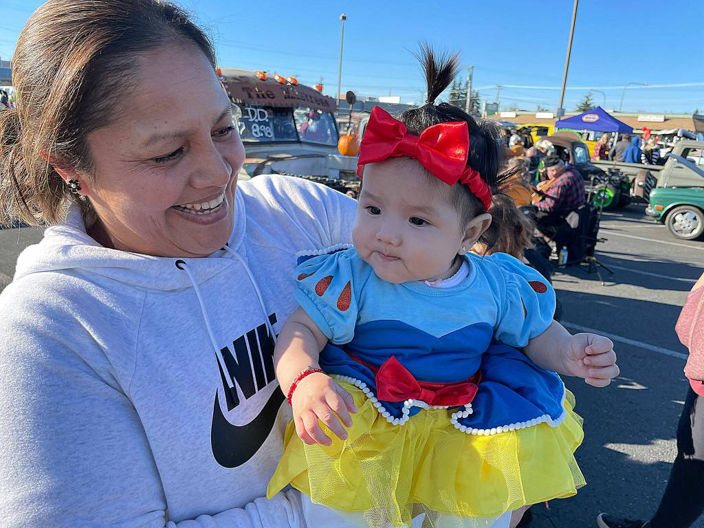 Alma Torres brings 5-month-old Gabriella Bahena around the Olympic Peninsula Rat Racers trunk-or-treat event for her first Halloween festivities as Snow White.