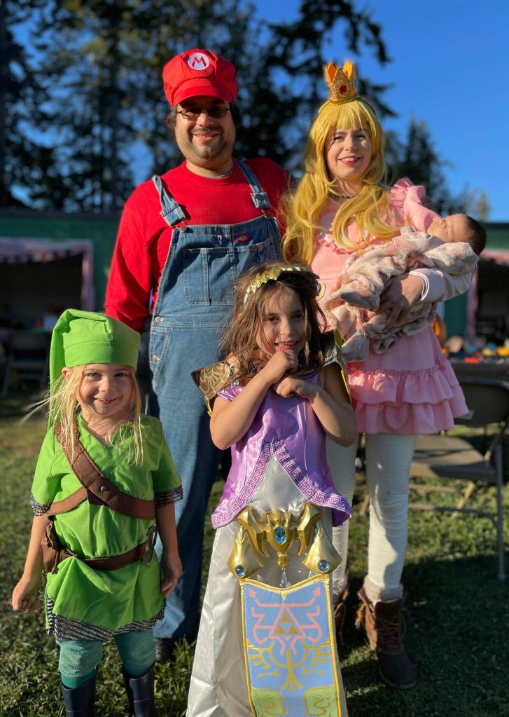 At left: From the screen of a Nintendo Switch to the Sequim Prairie Grange, this Nintendo family of Joel Parilla (Mario), Anika Reeves (Peach) with 2-month-old Meadow, Laszlo Kovach (Link), 2, and Fern Reeves (Zelda), 6, said they participated in pumpkin carving and festivities for the first time.
