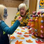 Dressed as a zombie Seahawks cheerleader, 5-year-old Glacier Linch pulls a lollipop for a prize with help from church member Judy Norton at Faith Lutheran Churchs Harvest Festival on Halloween night.
