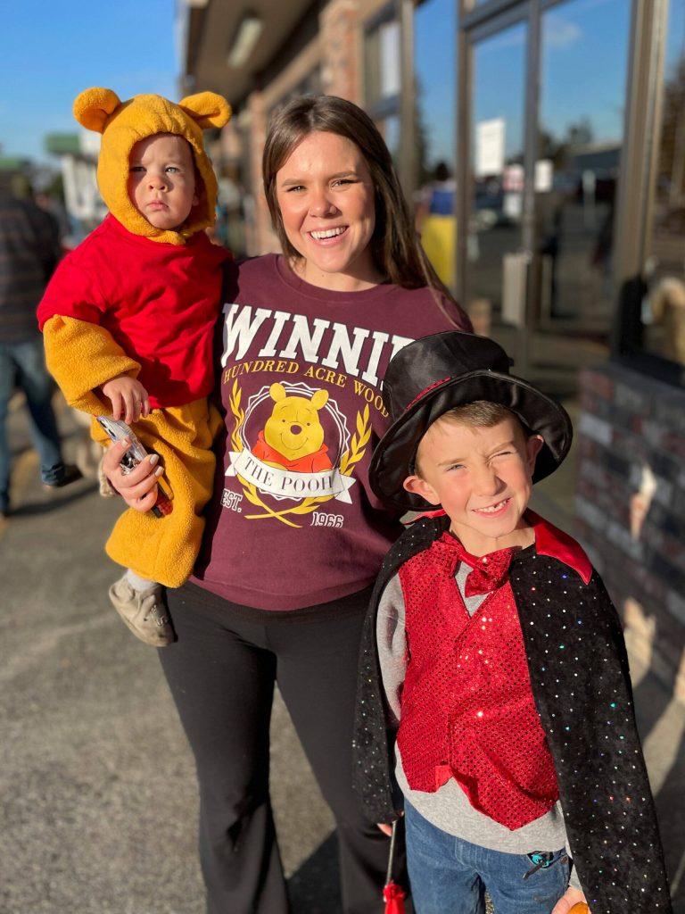 Sequim Gazette photo by Matthew Nash/ Juliet Breitbach, 1-year-old Donovan Breitbach, and six-year-old Zeke Huisman walk business to business in Creamery Square on Halloween during the Sequim Merchants annual event.