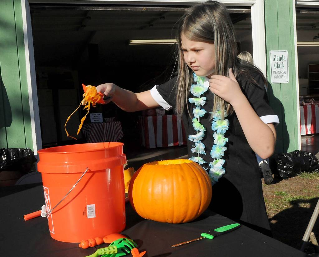 Keith Thorpe/Olympic Peninsula News Group/ Daria ONeill, 9, of Sequim empties the innards of a pumpkin at Sequim Prairie Grange Fall Festival & Trunk or Treat on Saturday at the grange hall and grounds near Carlsborg. The festival featured pumpkin carving, childrens games and treats handed out to costumed youngsters.