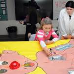Keith Thorpe/Olympic Peninsula News Group/ Sonnie Fountain, 8, of Sequim plays an oversized version of the Operation game under the direction of Sequim High School freshman Lillian Anderson during Saturdays Haunted Hallways holiday event at the school. Haunted Hallways featured a portion of the school set aside for a variety of Halloween games and attractions hosted by students as a benefit for the Sequim Food Bank.