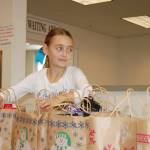 Sequim Gazette file photo by Erin Hawkins/ River Jensen, 10, hands out gift bags full of socks, hats and toiletries at the Salvation Army in Port Angeles in December 2016. She continues the project this year as a senior at Sequim High School.