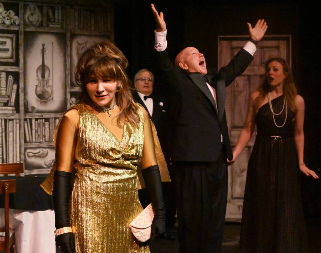 Sequim Gazette photo by Michael Dashiell / Acerbic magazine columnist Daria Chase (portrayed by Jamie Pauley) reveals that newly-married Simon Bright (Stephan Willms) has inherited a fortune in an early scene of The Games Afoot or Holmes for the Holidays. Looking on are host William Gillette (Joel Hoffman) and Brights new bridge, Aggie Wheeler (Merrin Packer).