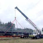 Photo courtesy of Clallam County Public Works / A bridge section that was formerly used as a walkway from downtown Seattle is unloaded at a Clallam County gravel pit facility.