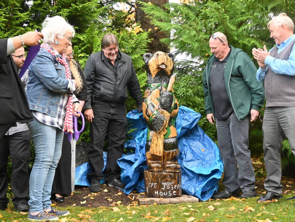 Sequim Gazette photo by Michael Dashiell / Betsy Reed Schultz (far left), founder of Captain Joseph House, gets a look at a carved bear donated by Bret Wirtas Black Bear Diner and Holiday Inn & Suites last week at the Port Angeles facility.