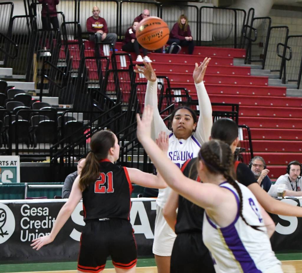 Photo by Jim Heintz / Sequims Jelissa Julmist, background, passes to teammate Sammie Bacon in the first half of the Wolves 57-37 win over Sammamish in March, in a Round of 12 game of the class 2A state tourney in Yakima. Julmist joins fellow 2023 Sequim High grad Hannah Bates on the 2023-24 Peninsula College roster.