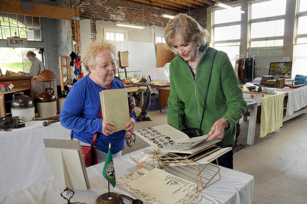 Maureen Sandison, left, and Valle Nevaril, both of Port Angeles, examine high school year books on sale at the North Olympic History Center's Vintage Sale on Saturday at the former Lincoln School in Port Angeles. The sale, which included collectables, vintage clothing, tools and other items, was designed to benefit the center's programs and operations. (Keith Thorpe/Peninsula Daily News)