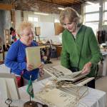 Maureen Sandison, left, and Valle Nevaril, both of Port Angeles, examine high school year books on sale at the North Olympic History Centers Vintage Sale at the former Lincoln School in Port Angeles in May.