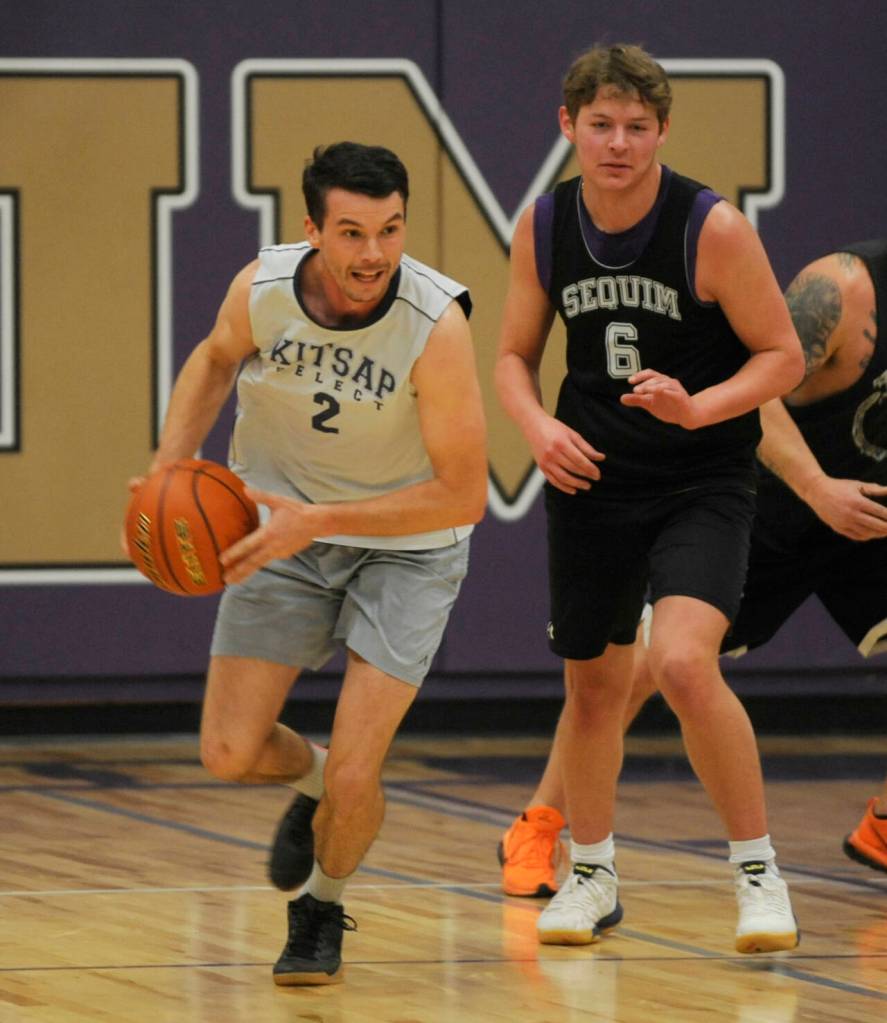 Sequim Gazette photo by Michael Dashiell / Sequim High alum Jayson Brocklesby, left, and Zack Thompson push the ball upcourt in the Nov. 24 alumni game at Rick Kaps Gymnasium.