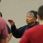 Long-time head coach and assistant coach Steve Chinn talks with his wrestlers at a preseason practice last week. Chinn took over mid-season in 2022-23 after the passing of coach Chad Cate and returns for another season of leading the Wolves in 2023-24.