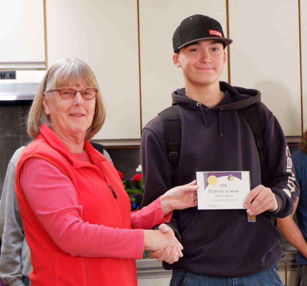 Photo courtesy of Sequim School District / Kathy Strozyk of Sequim Sunrise Rotary hands Sequim high School student Maximus Brook