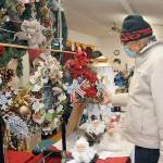Arthur Seward of Sequim examines a display of handmade wreaths created by Sequim-based The Hitching Post during Saturday's Holiday Craft Fair at the Sequim Prairie Grange near Carlsborg. The fair featured a variety of holiday-themed crafts and gifts made by local artisans, as well as lunch prepared by grange members. (Keith Thorpe/Peninsula Daily News)