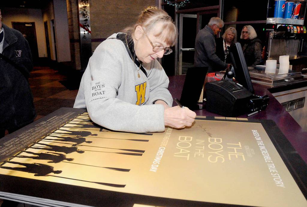 Photos by Keith Thorpe/Olympic Peninsula News Group
Judy Willman, daughter of University of Washington rowing team member Joe Rantz, signs a movie poster for the movie The Boys in the Boat, a tribute to the teams rise to winning a gold medal in the 1936 Olympics.