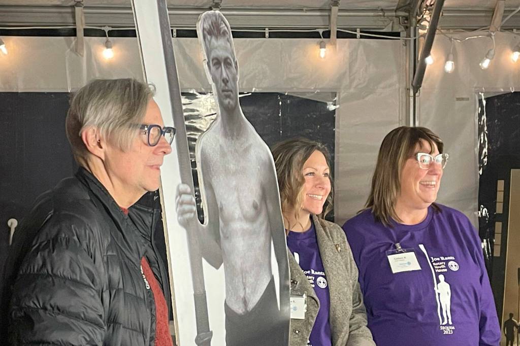 Sequim Gazette photo by Matthew Nash/ During the Tribute to Joe Rantz event at the Sequim Museum and Arts, Craig Robinson, Chelsea Reichner and Colleen Robinson pose for a photo with a cutout of Joe Ratnz.
