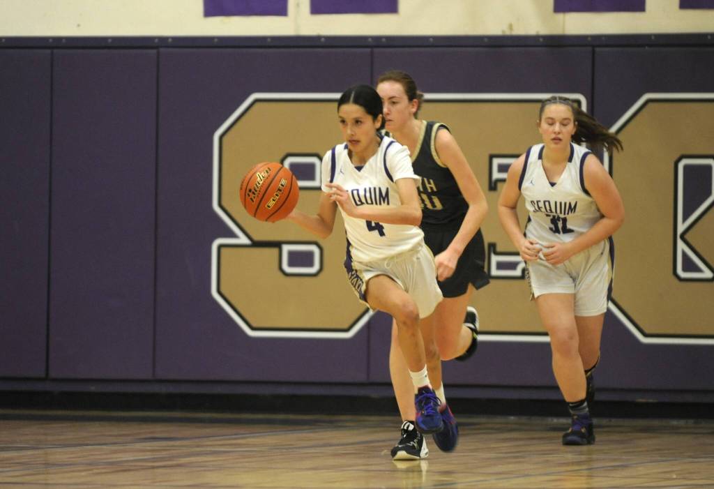 Sequim Gazette photo by Michael Dashiell / Sequims Gracie Chartraw, left,pushes the ball upcourt in the Wolves 56-40 home win over North Kitsap on Dec. 15.