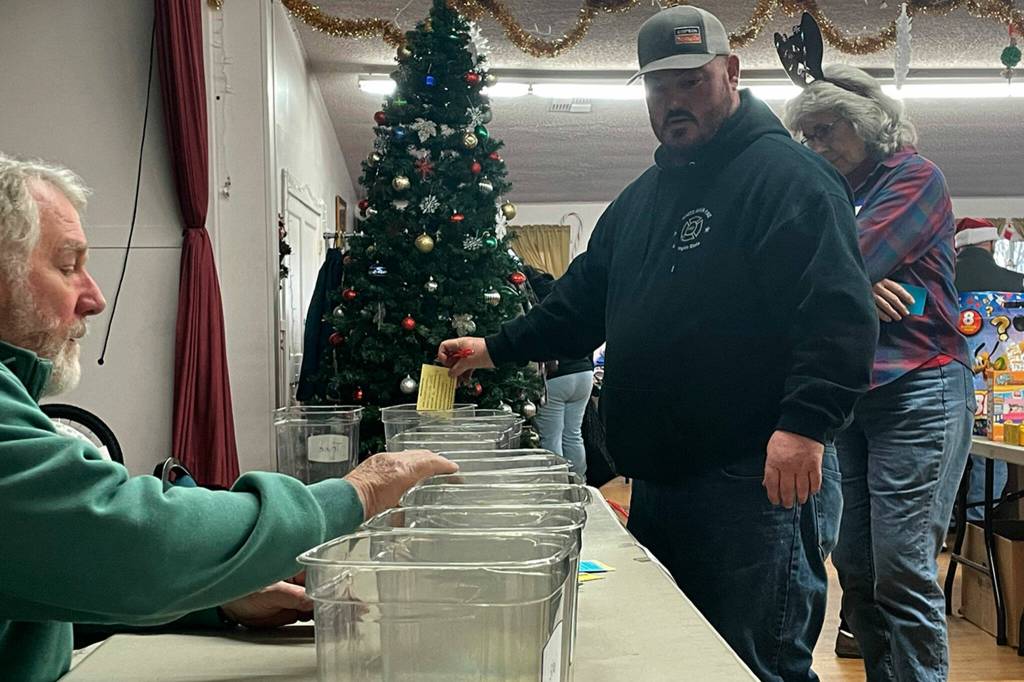 Sequim Gazette photo by Matthew Nash/ Jim Ryan, left, helps Kenneth Weeda choose a bike for a raffle at Toys for Sequim Kids. Murreys Olympic Disposal donated 22 bikes this year, organizers said.