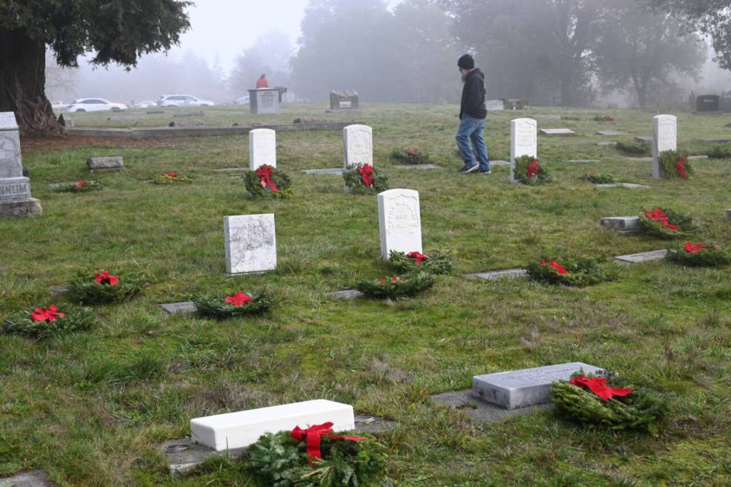 Sequim Gazette photo by Michael Dashiell / Dozens of community members turn out to place balsam wreaths on grave markers at Sequim View Cemetery on Dec. 16.