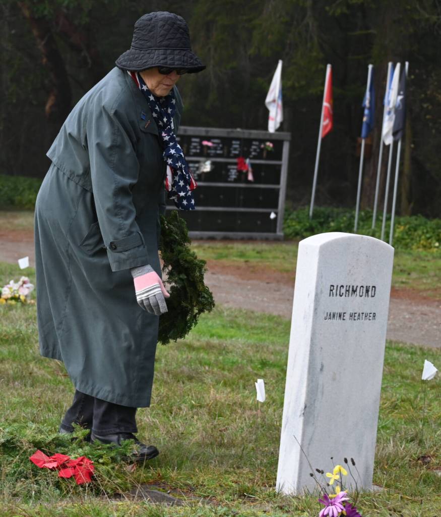 Sequim Gazette photo by Michael Dashiell / Melody Albertson, Michal Trebert Chapter DAR chaplain, lays a wreath on a veterans grave marker at a special wreath-laying ceremony held Dec. 16 at Sequim View Cemetery.