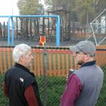 Photo by Keith Thorpe/Olympic Peninsula News Group / Port Angeles Dream Playground board member Steve Hargis, left, and board president Steve Methner confer outside the fence of Erickson Playfield after the playground went up in flames in the early morning hours of Dec. 20.