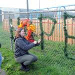 Photo by Keith Thorpe/Olympic Peninsula News Group / Jo Johnston, left, and Leia Kenton spell out a message of hope on the fence of Erickson Playfield after the Dream Playground was burned on Dec. 20 in Port Angeles.