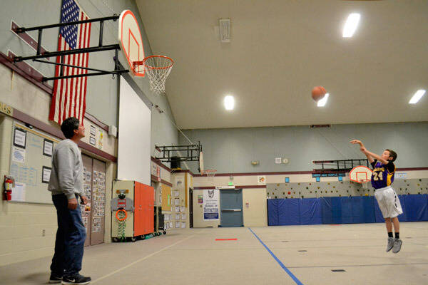 Sequim Gazette file photo by Matthew Nash / Garrett Little, then 9 years old, shoots a free throw during a practice at Greywolf Elementary with his dad Gary in 2016. Little qualified for the Elks Hoop Shoot National Finals free throw contest that year and again in 2019.