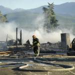 Sequim Gazette photo by Michael Dashiell / Firefighters with Clallam County Fire District 3 extinguish a fire after a home exploded on the 100 block of June Place in July.