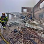 Photo by Jay Cline/Clallam County Fire District 2 / Firefighters from Clallam 2 Fire-Rescue and the Port Angeles Fire Department on May 7 help quell the remains of a fire that destroyed the Olympic National Park Day Lodge.