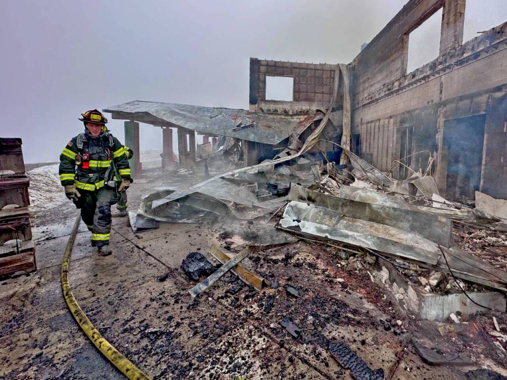 Photo by Jay Cline/Clallam County Fire District 2 / Firefighters from Clallam 2 Fire-Rescue and the Port Angeles Fire Department on May 7 help quell the remains of a fire that destroyed the Olympic National Park Day Lodge.