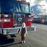 Photo courtesy of Ruby Miller family / Ruby Miller poses for a photo by a Clallam County Fire District 3 engine after she racked up the top donation figure ($630) at the 2023 Turkey Trot in November.
