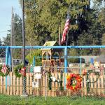 Wreathes, personal notes and flowers adorn the fence outside the Dream Playground at Erickson Playfield in Port Angeles on Tuesday after much of the playground was destroyed by fire last week. (Keith Thorpe/Peninsula Daily News)