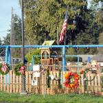 Photo by Keith Thorpe/Olympic Peninsula News Group 
Wreathes, personal notes and flowers adorn the fence outside the Dream Playground at Erickson Playfield in Port Angeles on Dec. 26 after much of the playground was destroyed by fire the previous week.