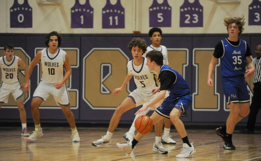 Sequim Gazette photo by Michael Dashiell / Sequims Garrett Little (5) and SHS teammates defend the basket as North Masons Cameron Revelez looks to score in the first half of Sequims 70-56 win on Jan. 2.